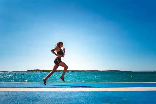 Woman running showing strong leg muscle Westcliff on Sea